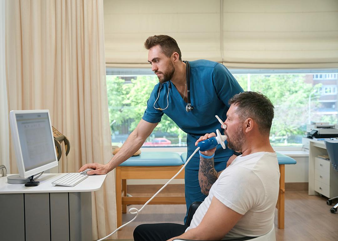 A pulmonologist checking a patient's lung functions during a spirometry test.