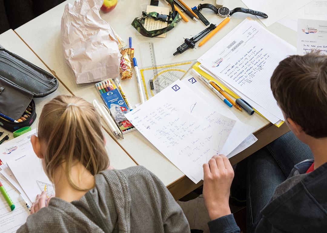 A pair of mathematics students writing on paper during the finals of a math competition.