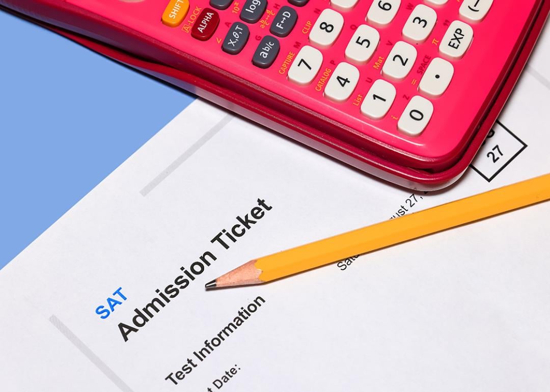 An SAT admission ticket under a pencil and calculator.