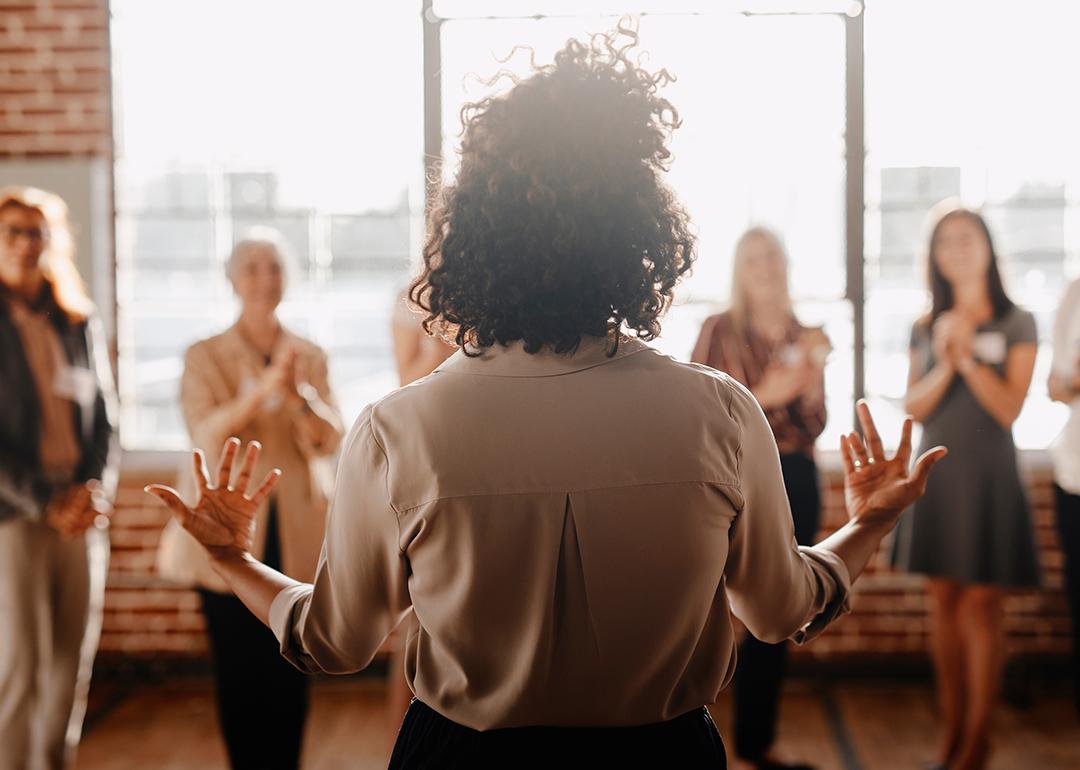 A woman in front of her colleagues leading a talk in the workplace.