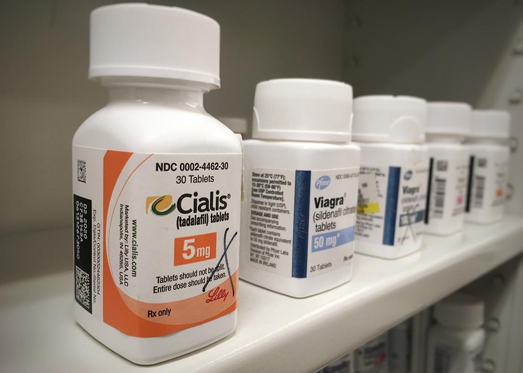 Bottles of Cialis and Viagra on a shelf.