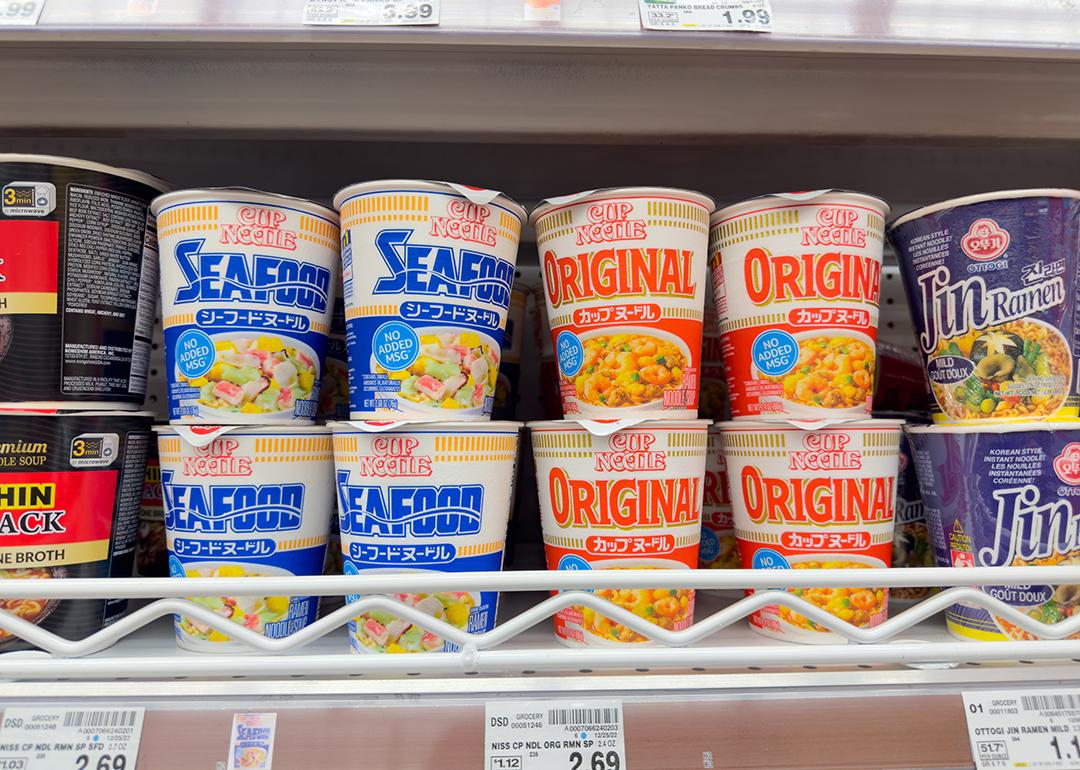 Assorted Cup Noodles packages on a grocery store shelf.
