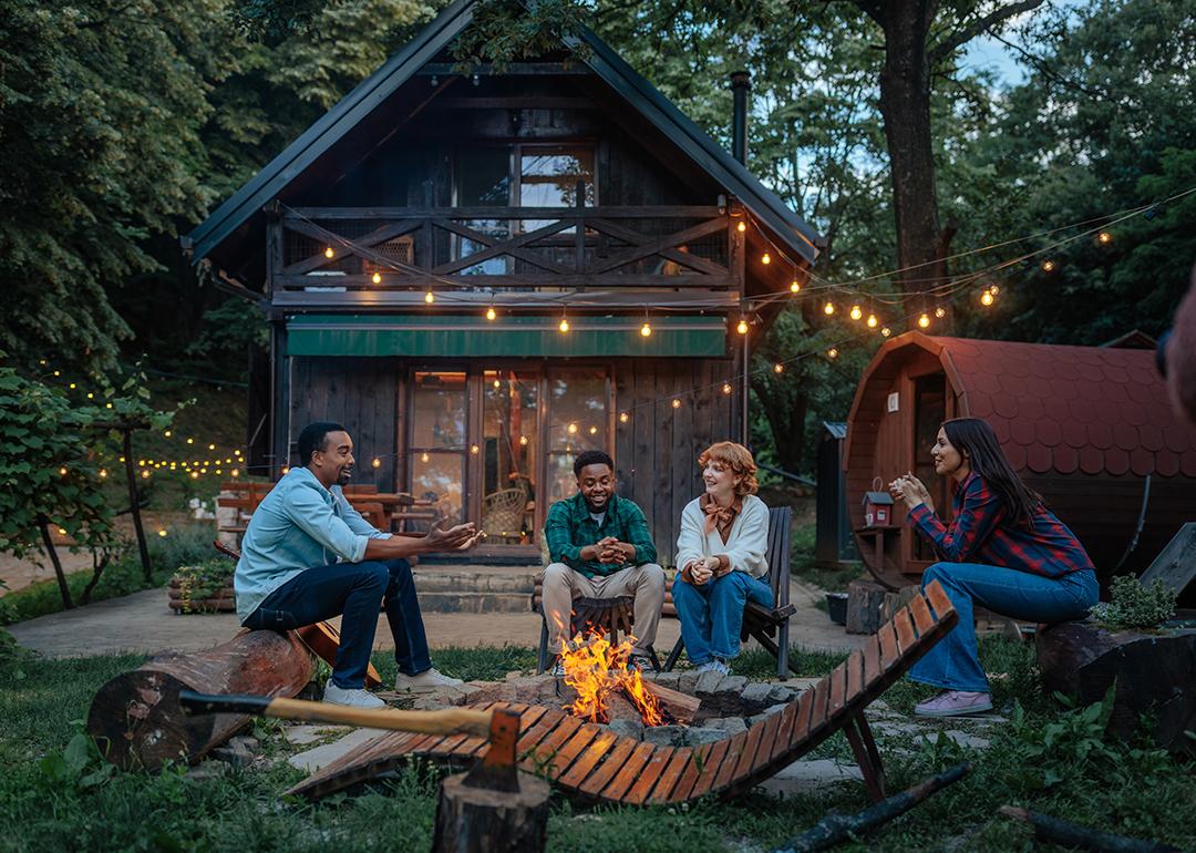 Four people sitting around a fire pit.