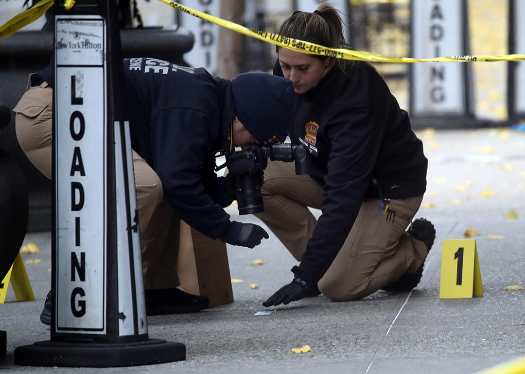Police take photos as they place bullet casing markers outside of a Hilton Hotel in Midtown Manhattan where United Healthcare CEO Brian Thompson was fatally shot on December 04, 2024 in New York City.