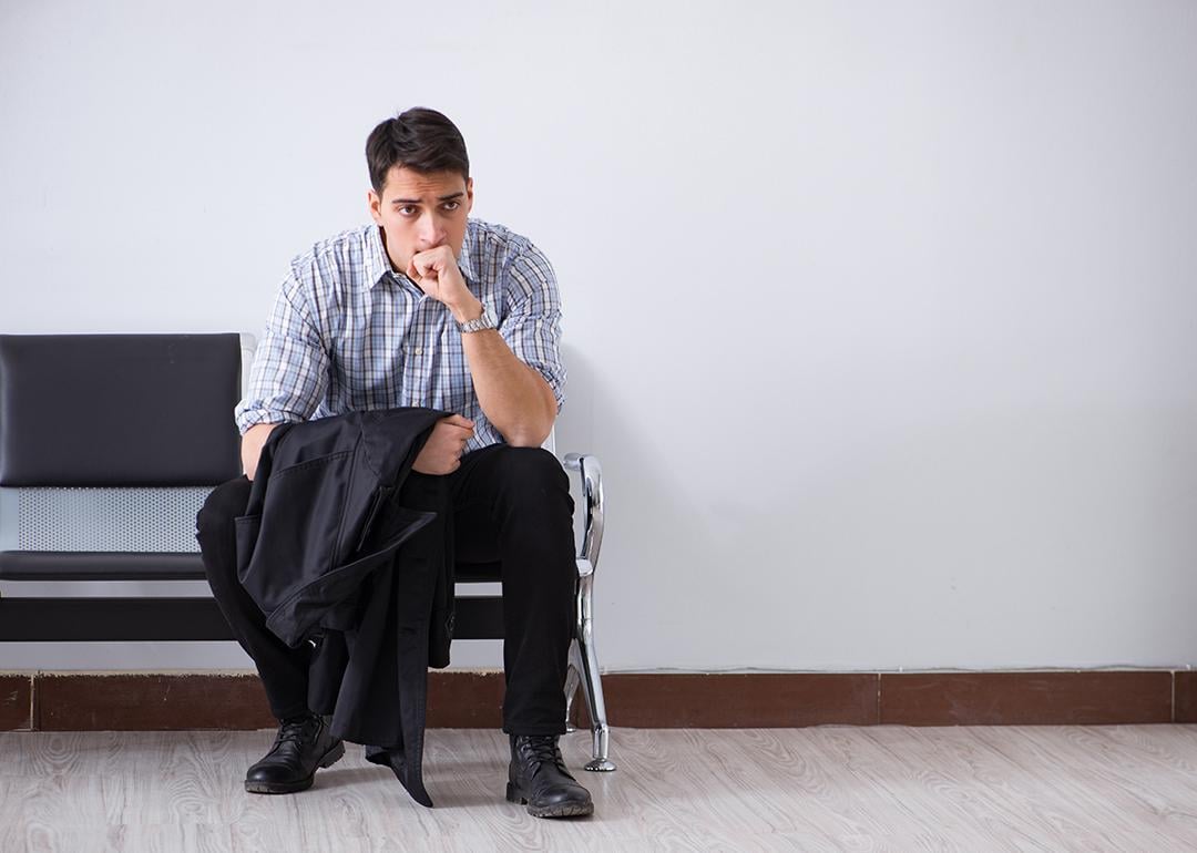 A man sits nervously waiting in a lobby.