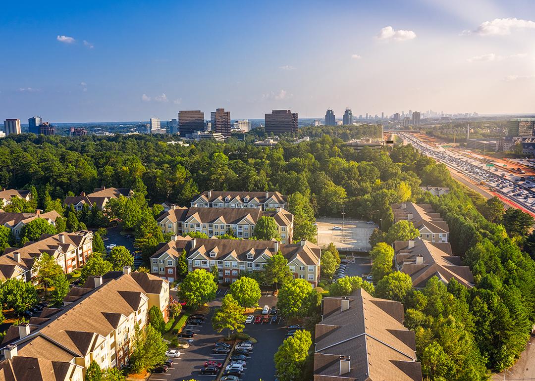 Condos in Atlanta suburbs just next to Highway GA 400 with blue sky and downtown in background.