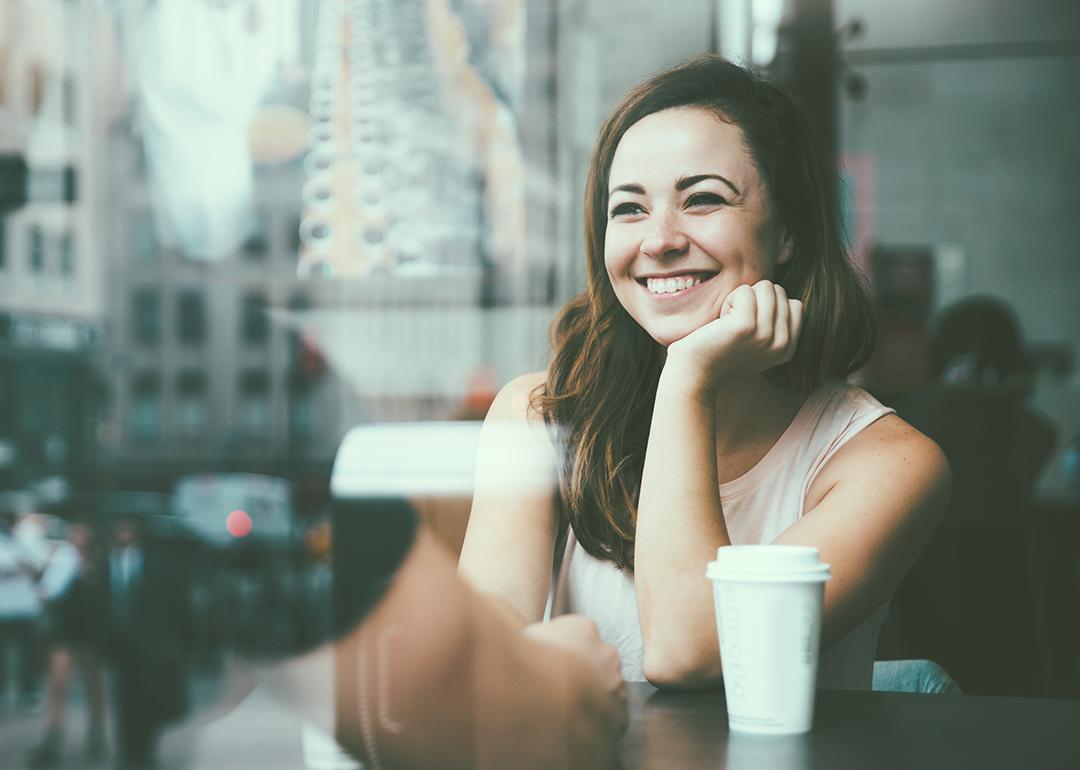 Couple sitting by the window glass side of a cafe, reflecting a great view of the city outdoors.