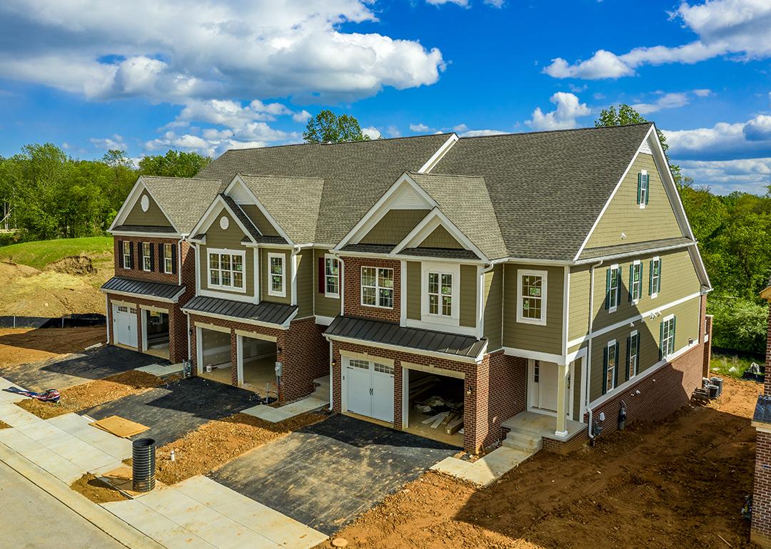 A large, modern triplex home nearing completion.