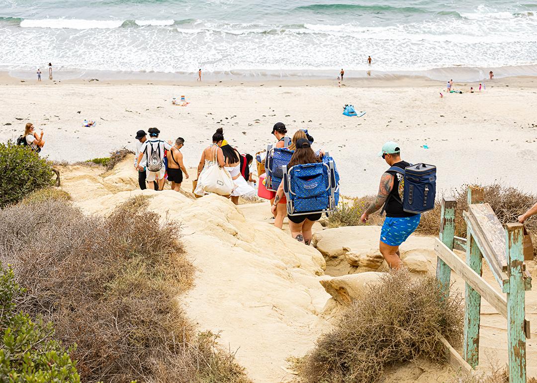 Tourists climb down the Torrey Pines cliffs heading towards Black's Beach in La Jolla in San Diego, California.