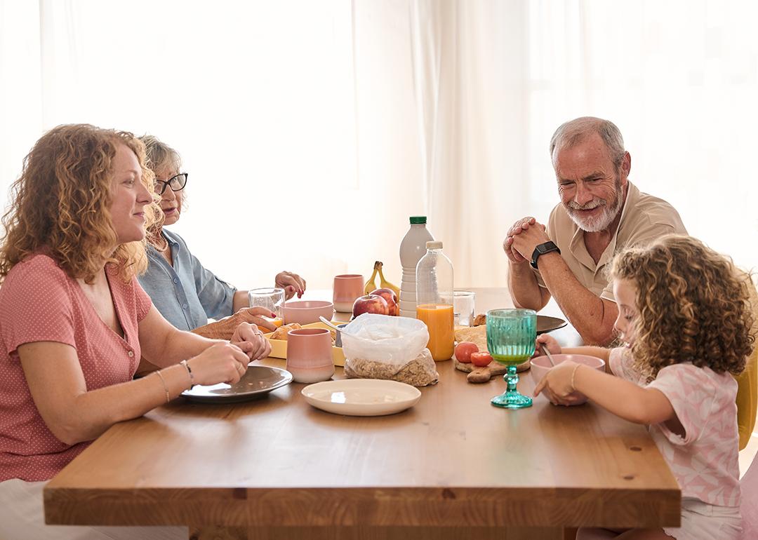 A happy family including grandparents seated in a table during breakfast.