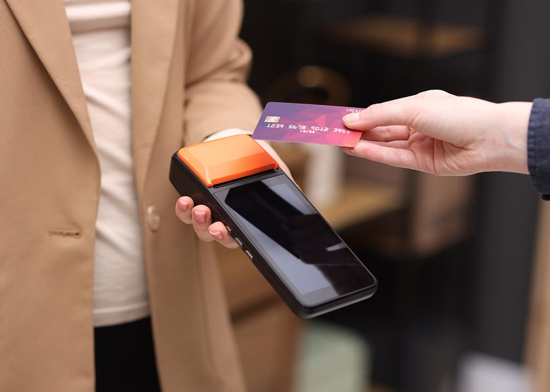 Person taps a business credit card on a payment terminal.