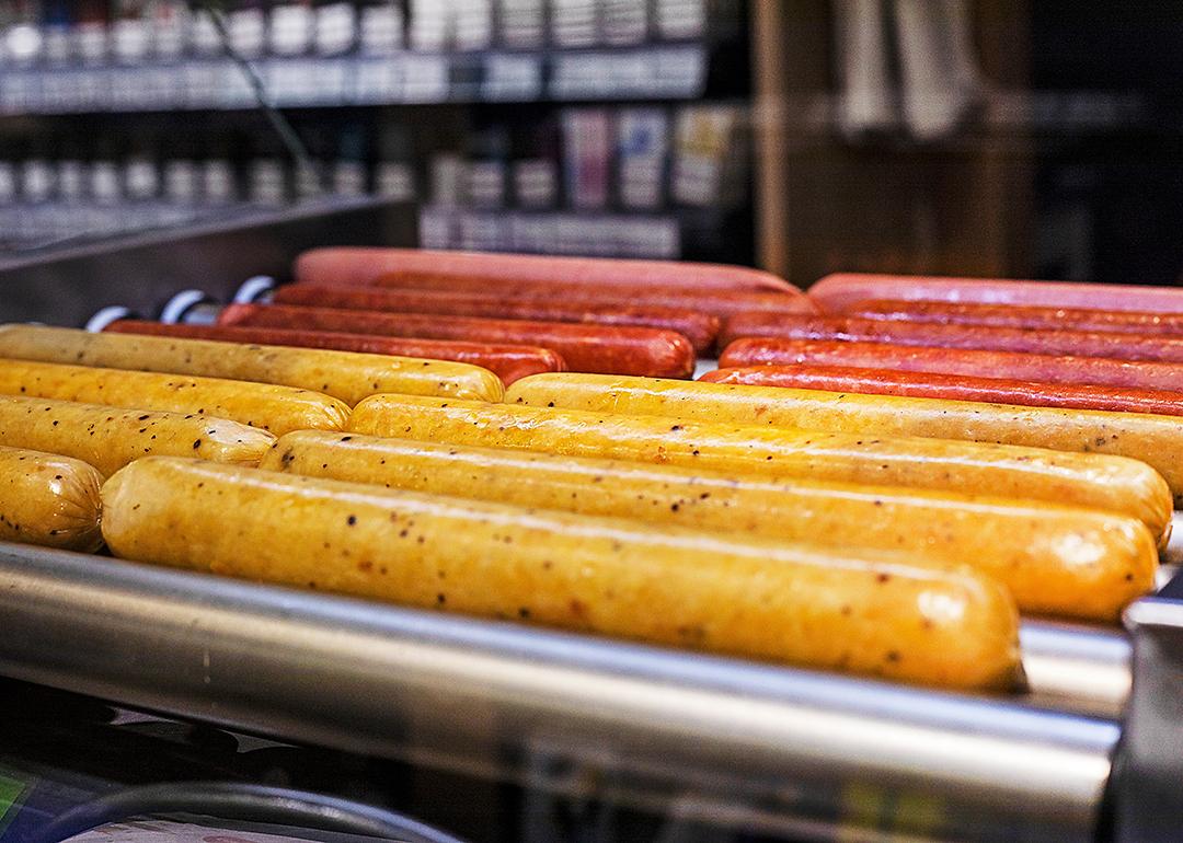 Hot dogs on a roller grill in a gas station.