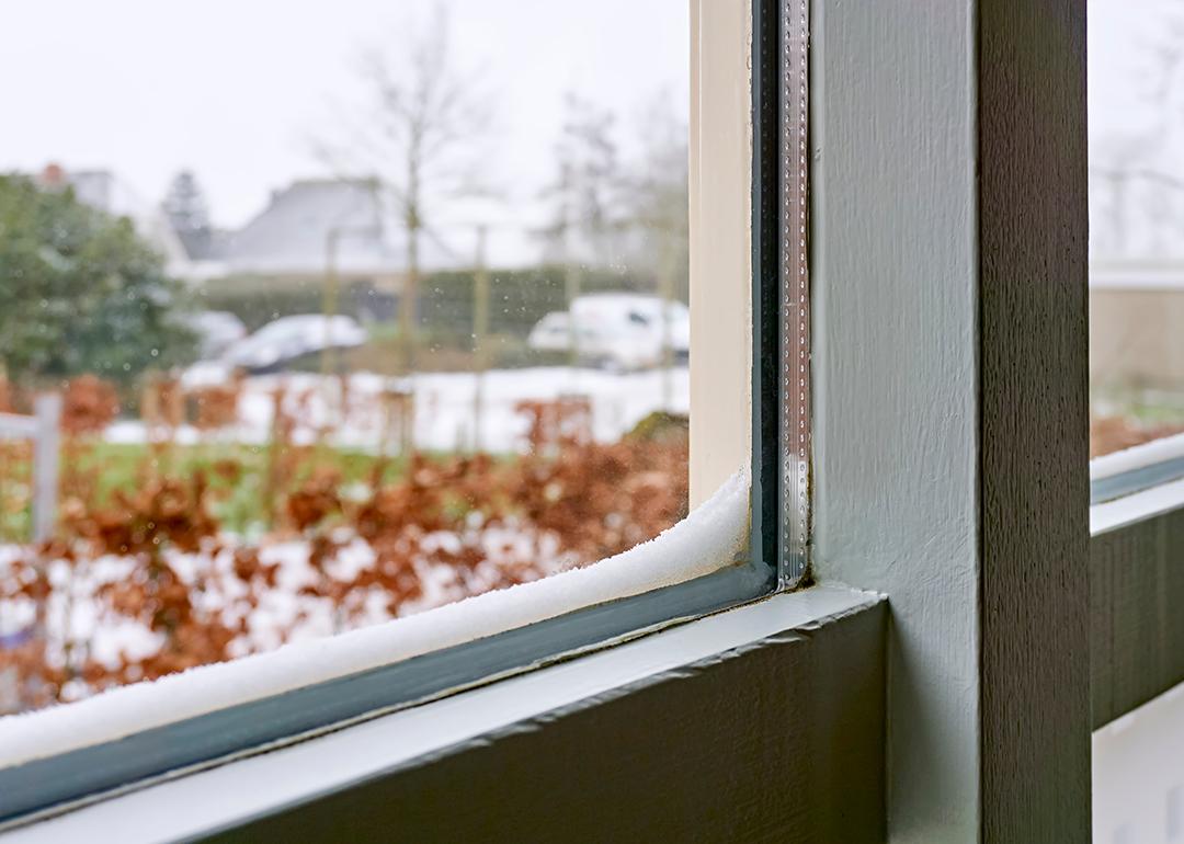 Double-glazed windows with accumulated snow on its edges.