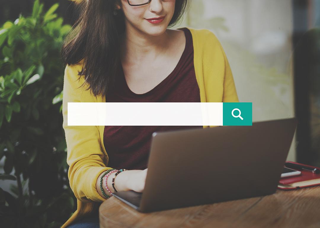 A search bar over a background of a woman using a laptop.