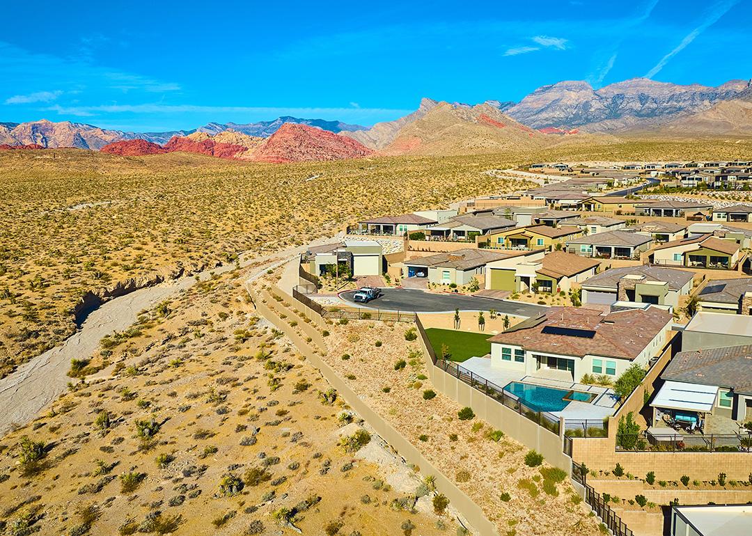 An aerial view of a modern suburban residential neighborhood situated in a mountainous desert area.