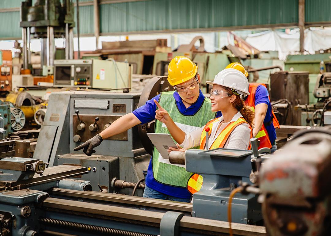 Heavy industry machine workers coordinating on site.