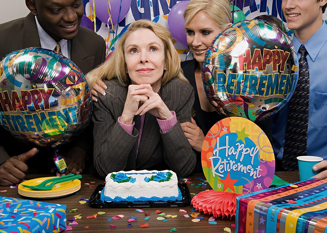 A female employee surrounded by her colleagues during her retirement party.
