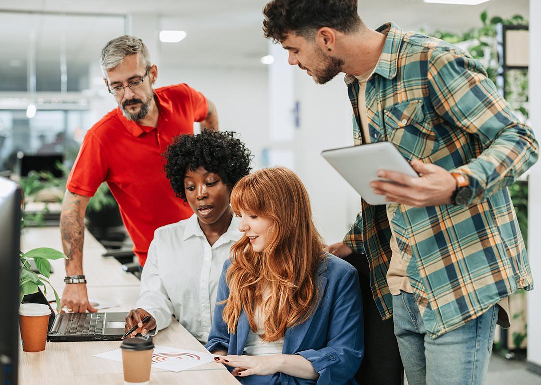 A diverse four-member team sharing ideas in an office.