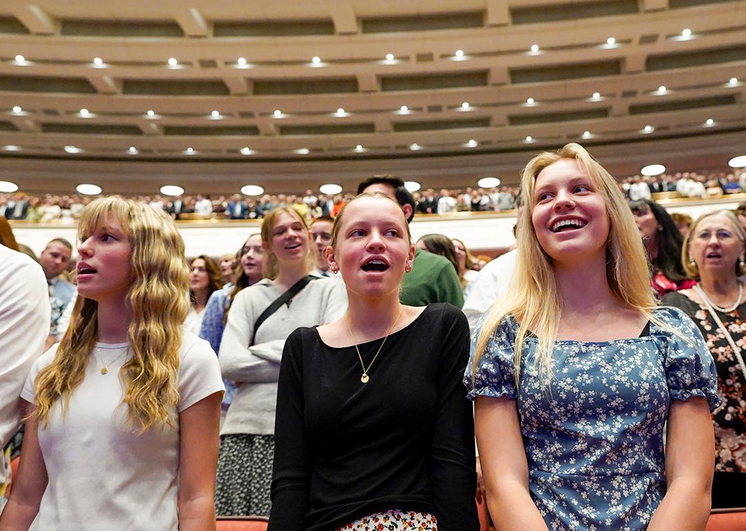 Low angle view of young women singing a hymn during a session of General Conference of The Church of Jesus Christ of Latter-day Saints in April 2025.