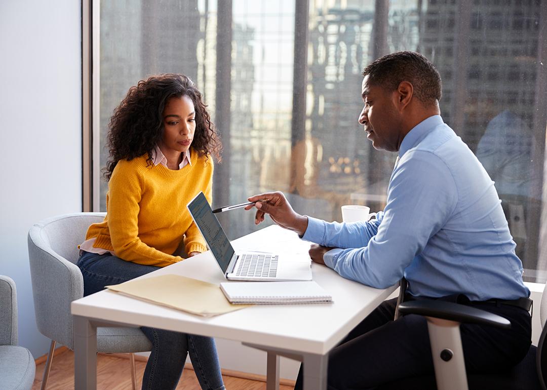 A young woman engaged in a discussion with a financial advisor in an office.