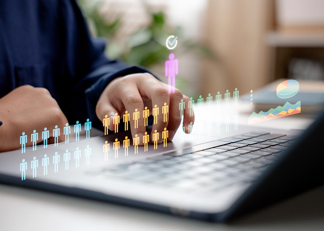 Concept of HR recruitment showing digital human figures illustrated over a businessperson using a laptop.