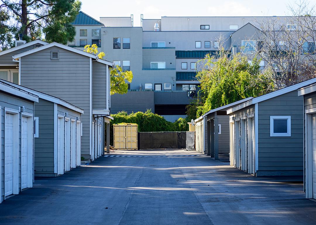 Symmetrical view of urban apartments' garages in a paved driveway.