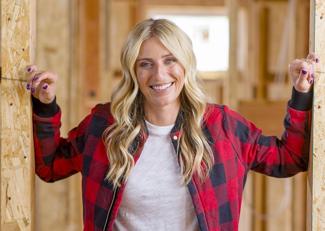 Jasmine Roth poses for a portrait inside a home renovation, wearing red and black buffalo check plaid.