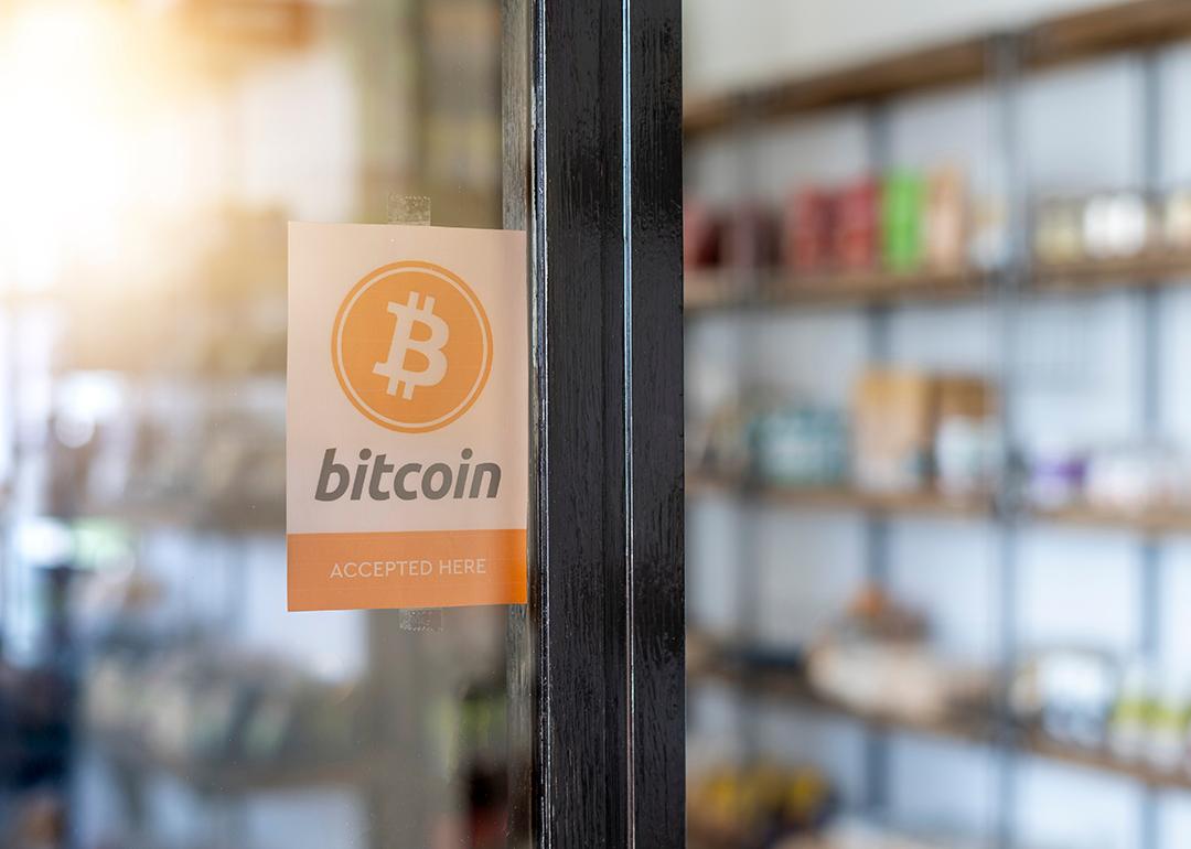 A entrance door sign showing 'Bitcoin (is) accepted here)'.