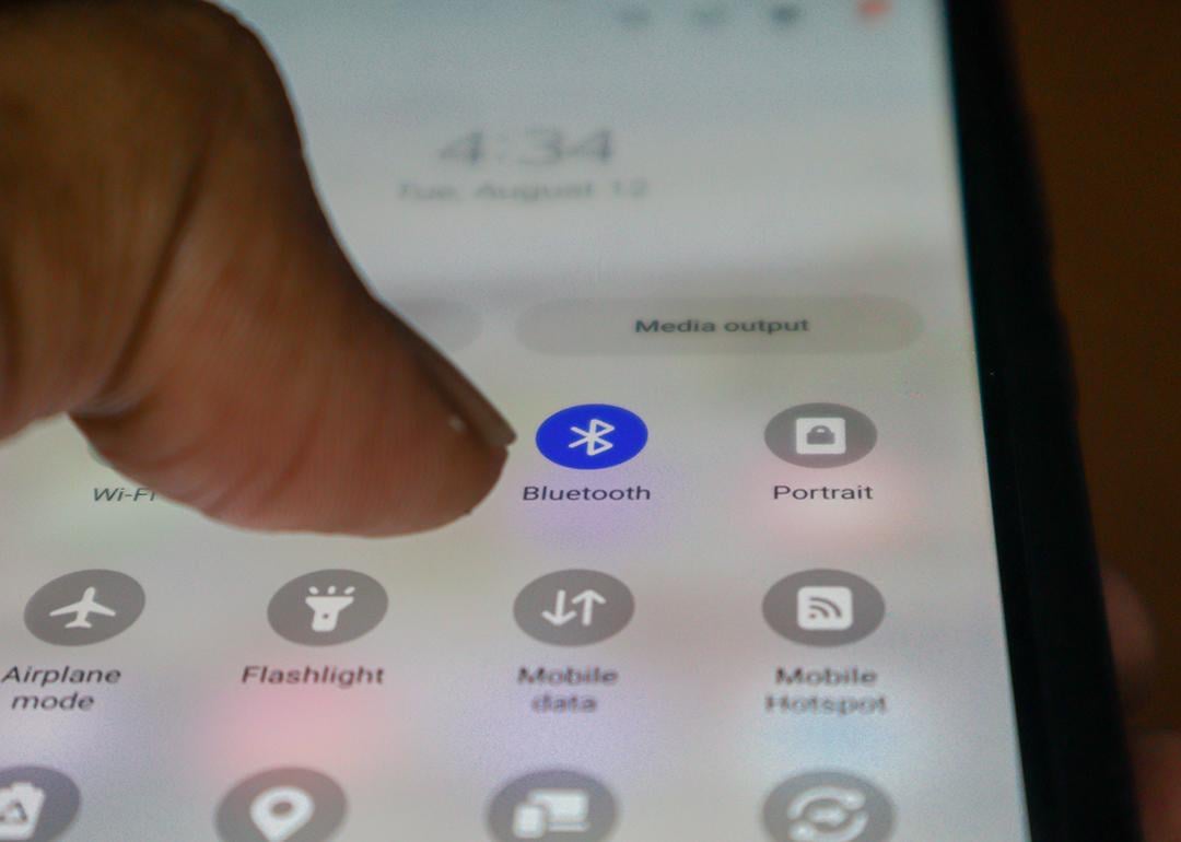 Close up view on a person's finger tapping on the bluetooth app on a phone.
