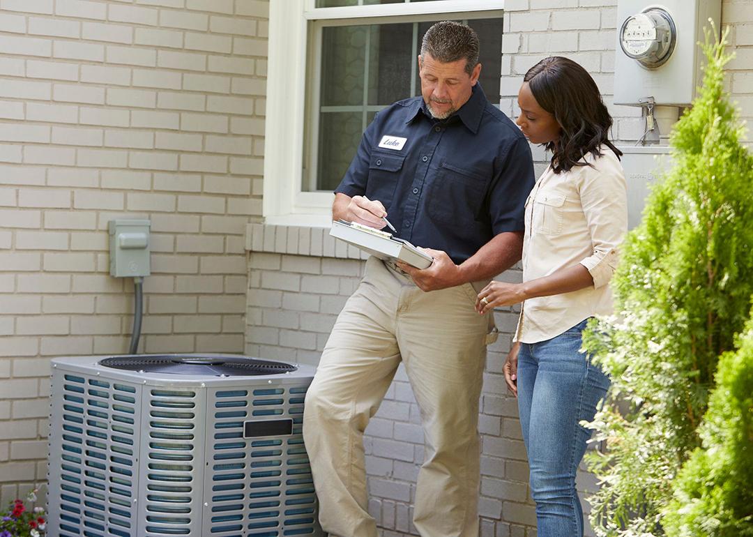 An AC vendor helping out a homeowner with instructions after installation.