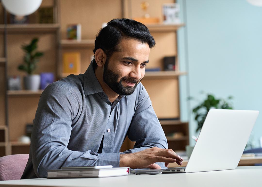 A happy business man working with a laptop in his home office.