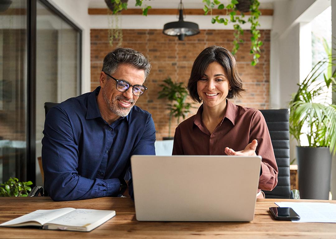 Two business executive leaders happily engaged in a discussion in an office.