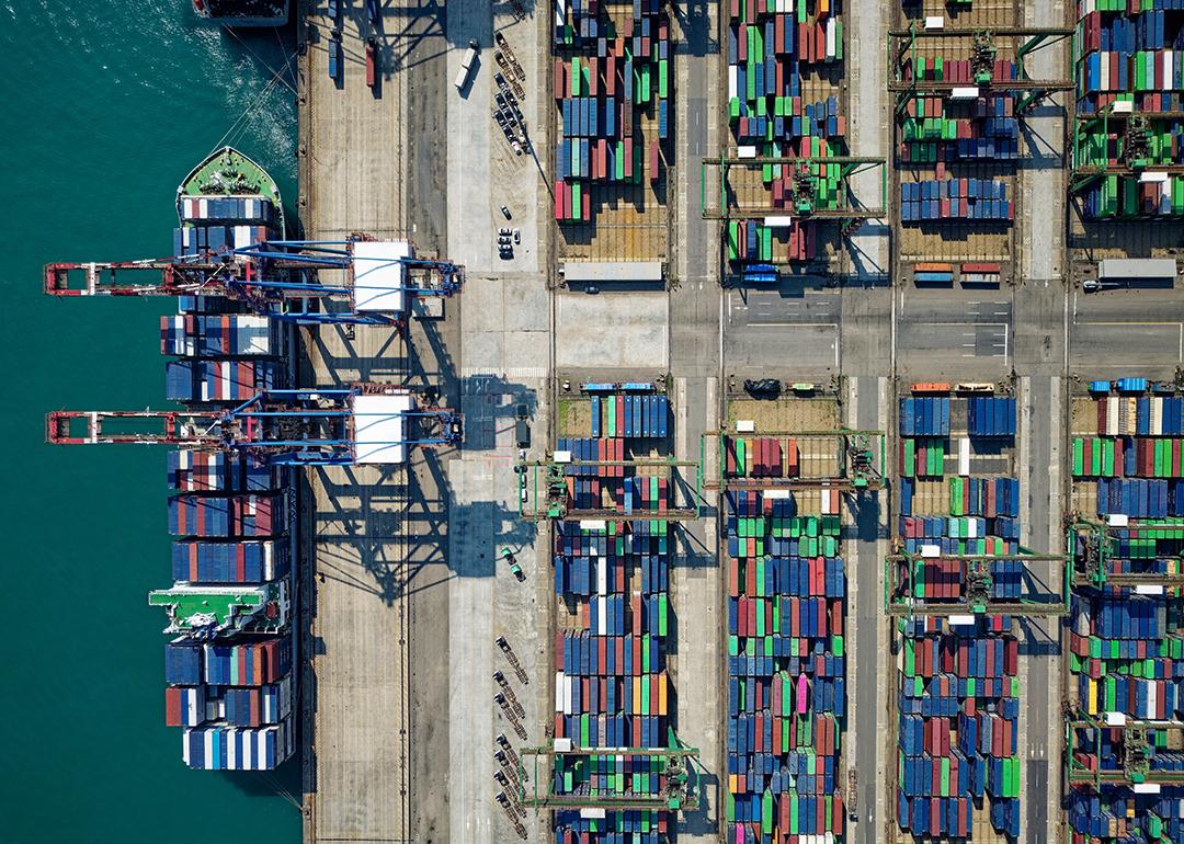 Aerial view on ships, cranes, and cargo containers by the quayside of a dock.