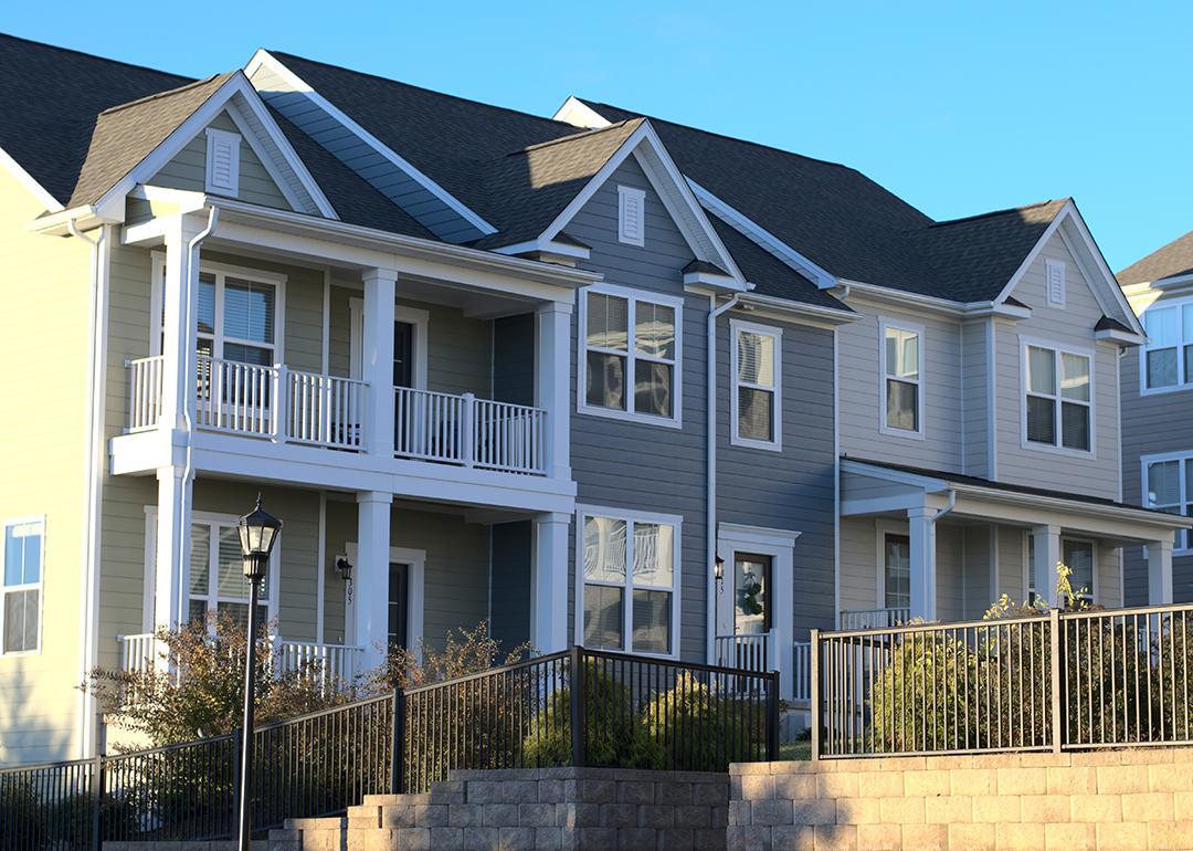 A row of townhouses with grey and white exterior in a housing community.
