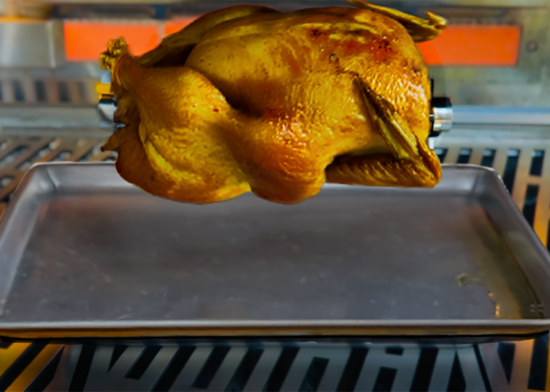 A chicken being roasted in a rotisserie oven.