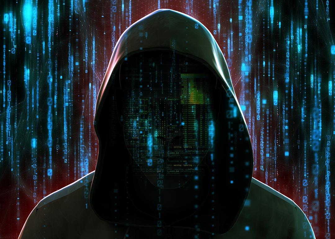 Illustration depicting cybersecurity concept with faceless figure of criminal in a hoodie against futuristic code background symbolizing AI technology.
