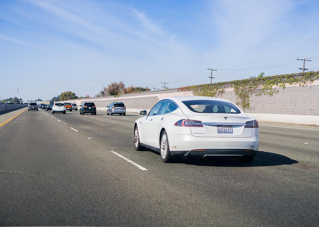 A white Tesla Model S driving on a freeway in San Francisco, California.