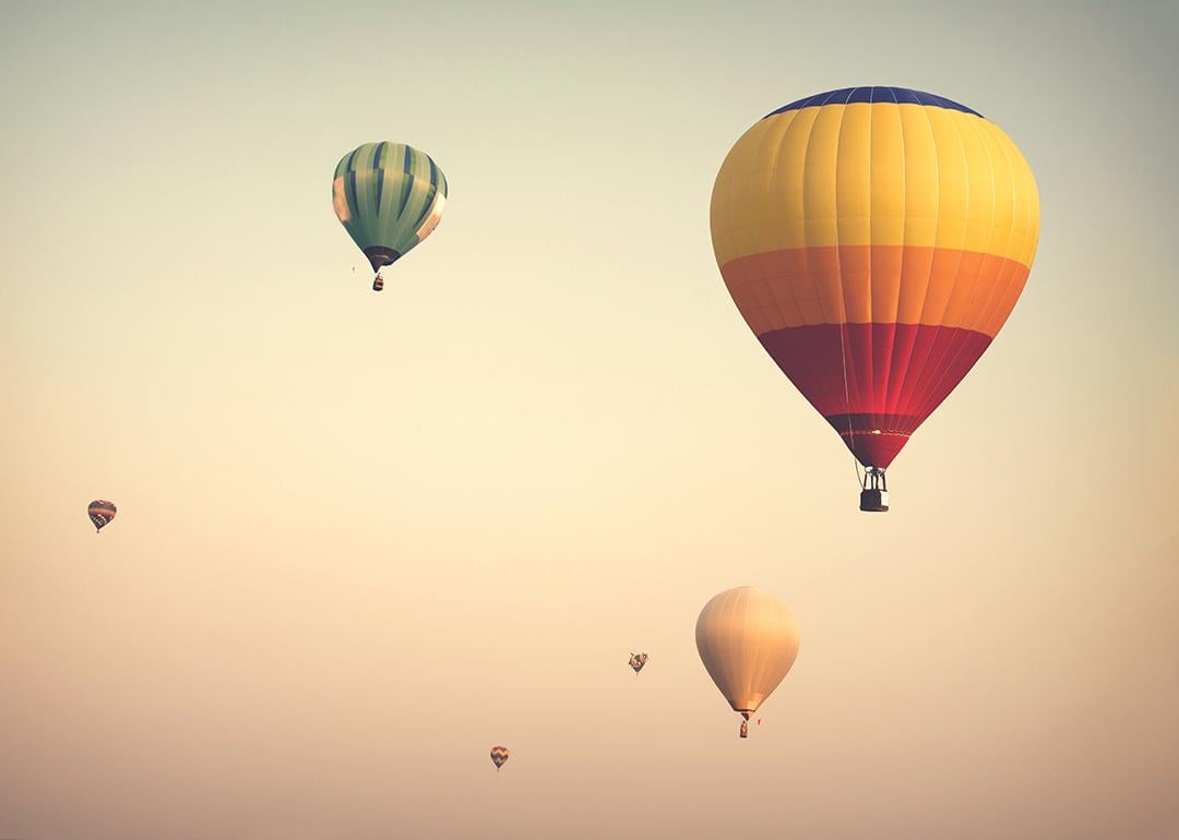 Hot air balloons up on a cloudy sky.