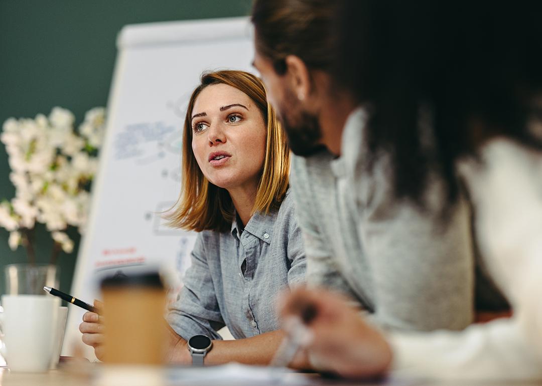 A young businesswoman in a meeting with her colleagues in a boardroom.