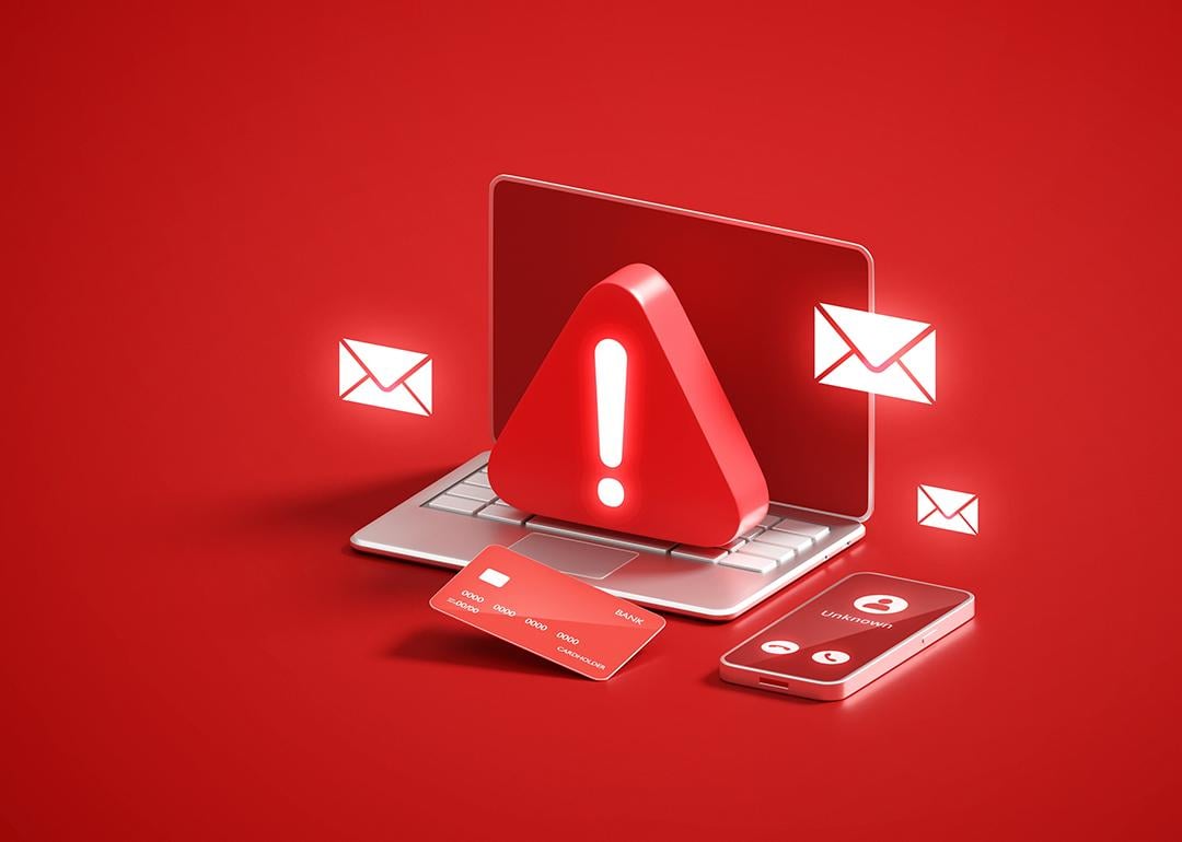 A red 3D illustration of a laptop with a warning sign as a concept of cyber scam or security threat.