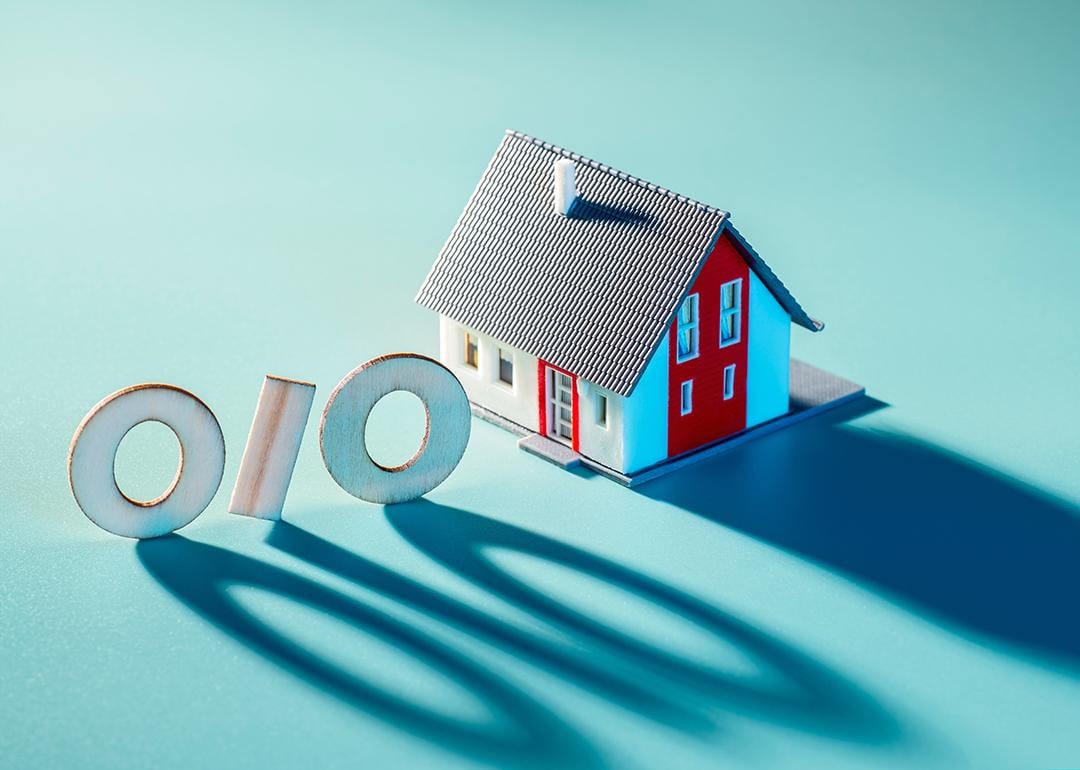 A 3D model of a house next to a percent figure with long shadows.