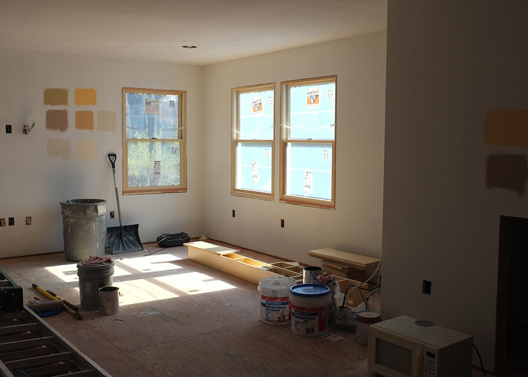 Paint samples on a wall of a sun-lit room with remodeling in progress.