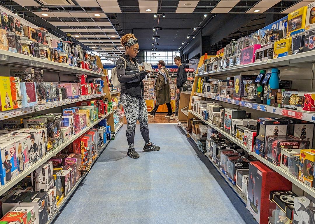  A young adult browsing in a toy and hobby shop aisle.