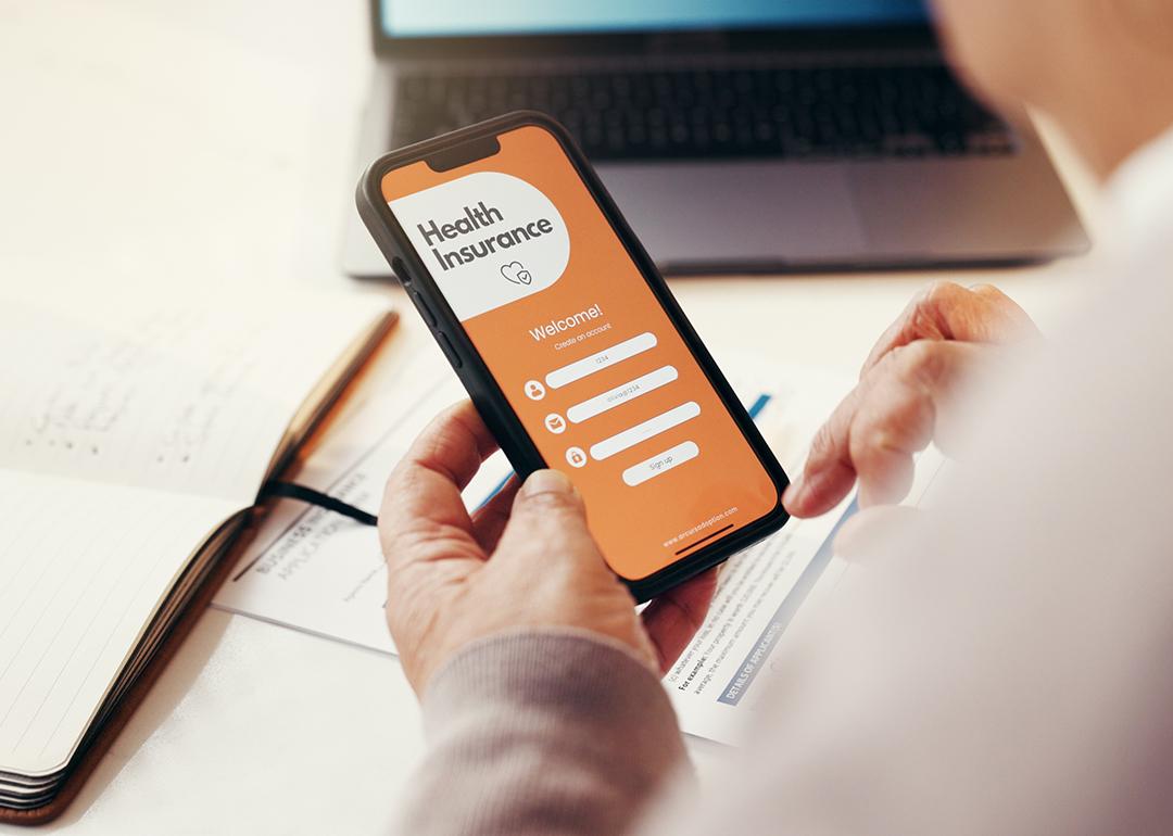 A senior person browsing a health insurance app on a smartphone.