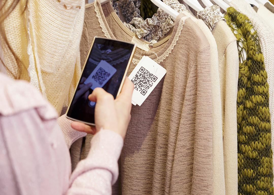 A woman scanning a clothing item's QR code on her phone.