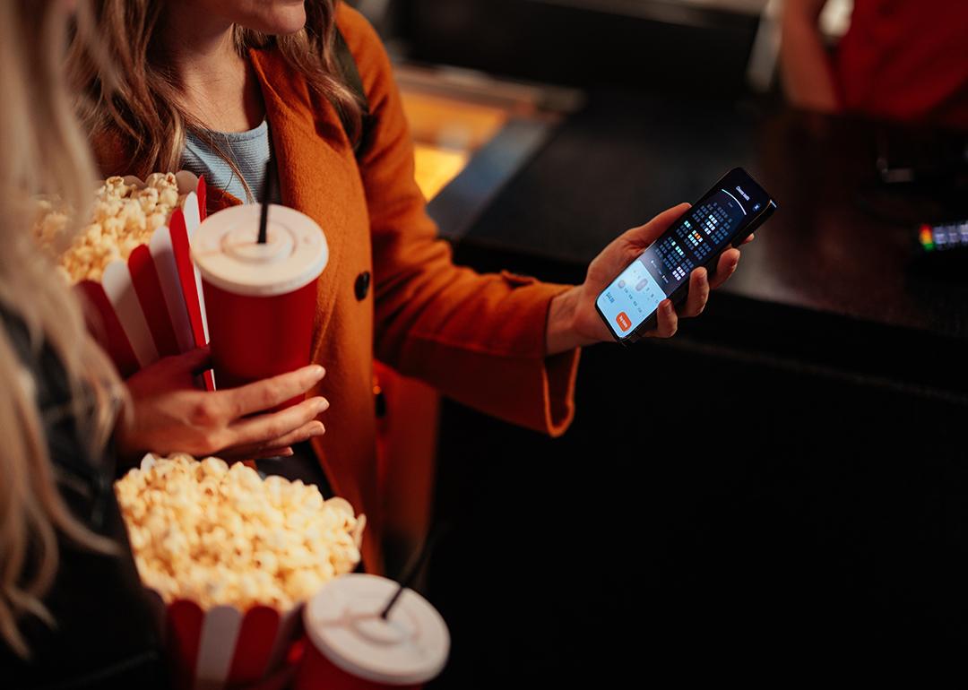 A young woman checking seats in a theater using a mobile app.