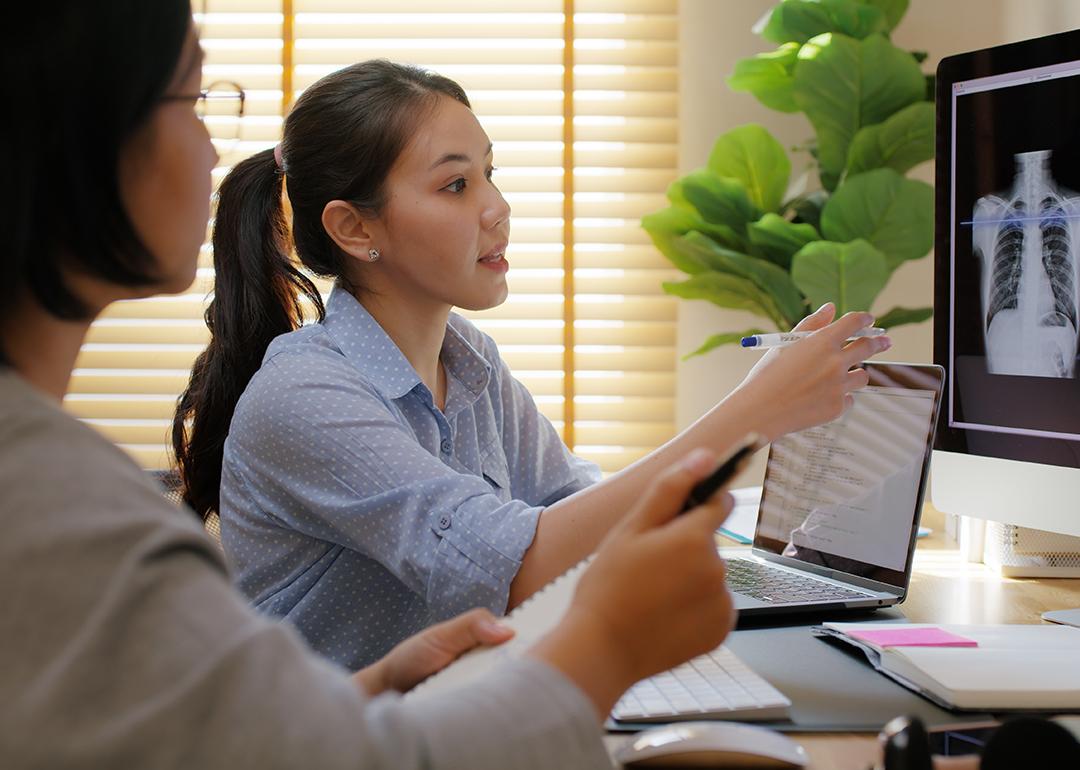 A female health care professional showing a patient x-ray results.