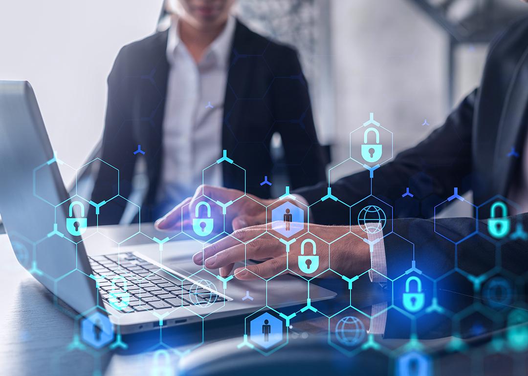 Two businesspeople in formal wear working on a project, with cyber security technology graphics illustrated.