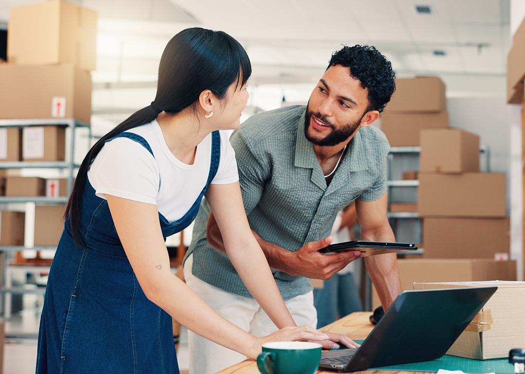 Startup business owners in their warehouse planning shipping and deliveries.
