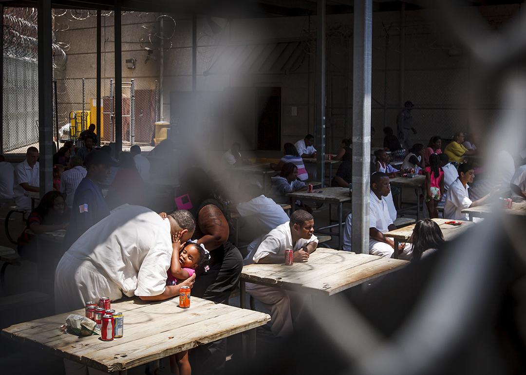 An inmate gives his daughter a hug and kiss during Father's Day at Joe Kegans State Jail's visiting hall.